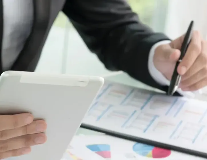 Berater wertet Energie- und Kostendiagramme auf einem Tablet aus