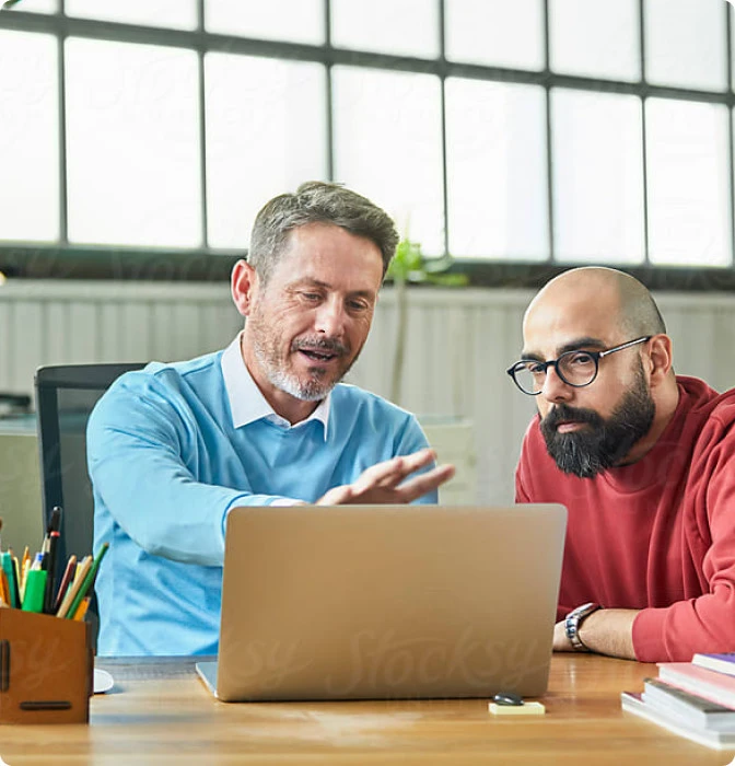 Zwei Franchise-Partner besprechen sich am Laptop im Büro