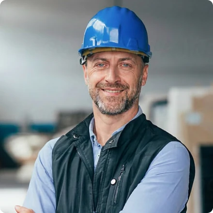 Ein Energieberater mit Helm verschränkt lächelnd die Arme