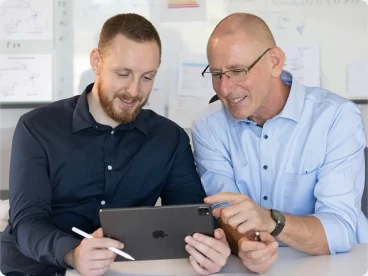 Zwei Berater besprechen Baupläne auf einem Tablet