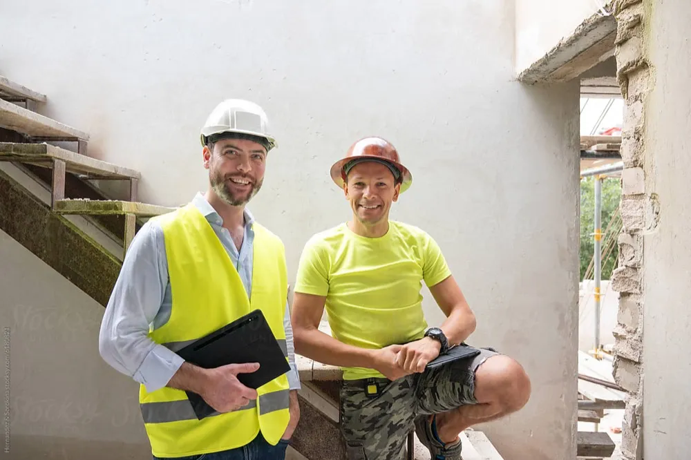 Zwei Bauleiter mit Schutzhelmen auf der Baustelle