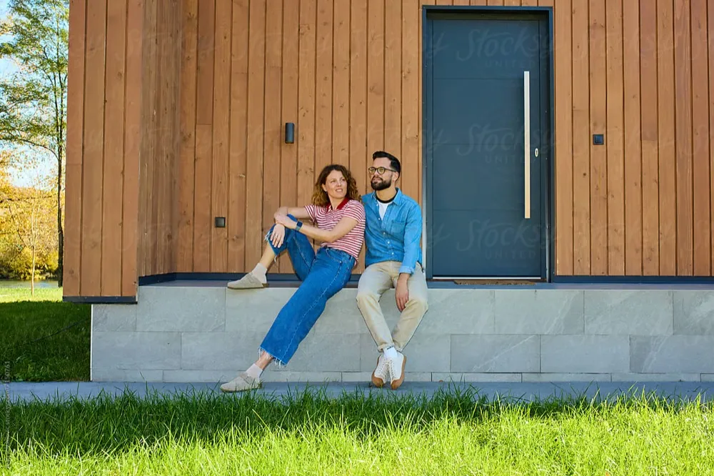 Kathrin und Marius M. sitzen zufrieden vor ihrem sanierten Haus