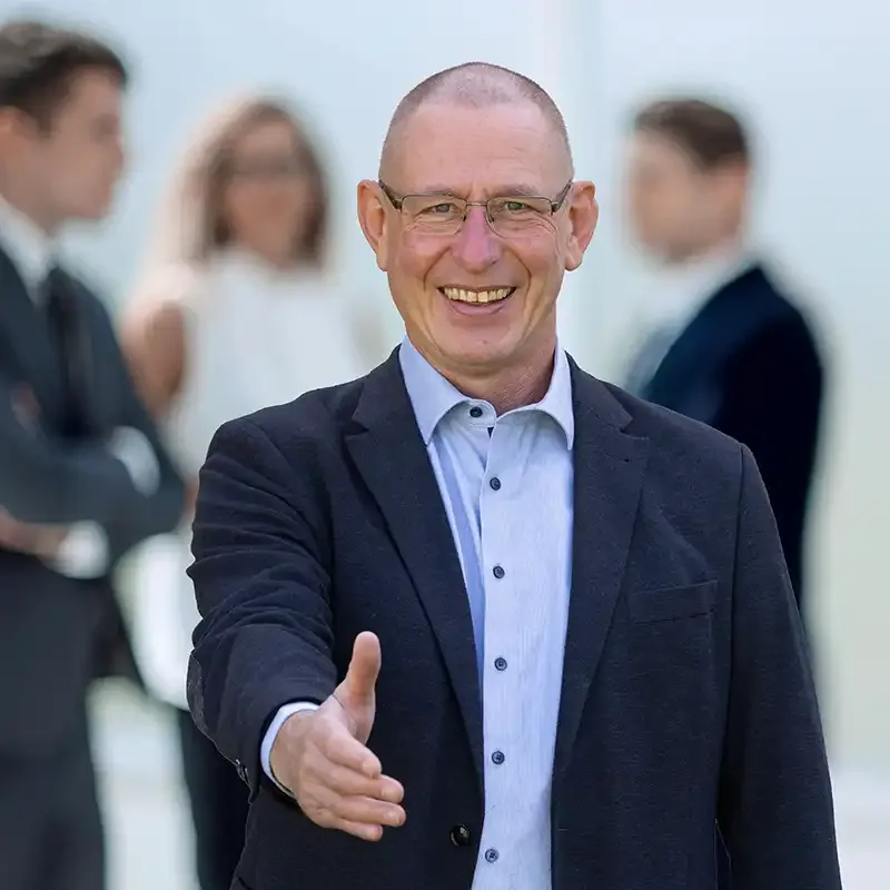Ein Energieberater lächelt und streckt die Hand zur Begrüßung aus